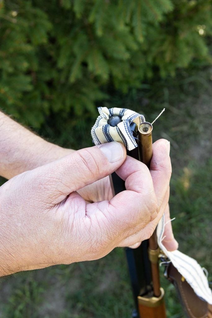 Wrap the projectile with the patch and place it squarely on the muzzle of the firearm.