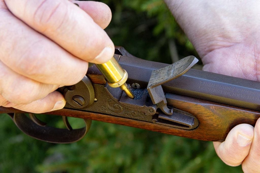 For flintlock firearms, open the frizzen and fill the pan 1/2 full with priming powder.